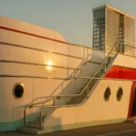 Streamline-Moderne-Pavillon am Meer mit geschwungener weißer Fassade zur goldenen Stunde